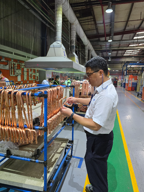 约克广州空调冷冻设备有限公司党支部党员汤忠桂正在研究如何改进生产工艺。.jpg